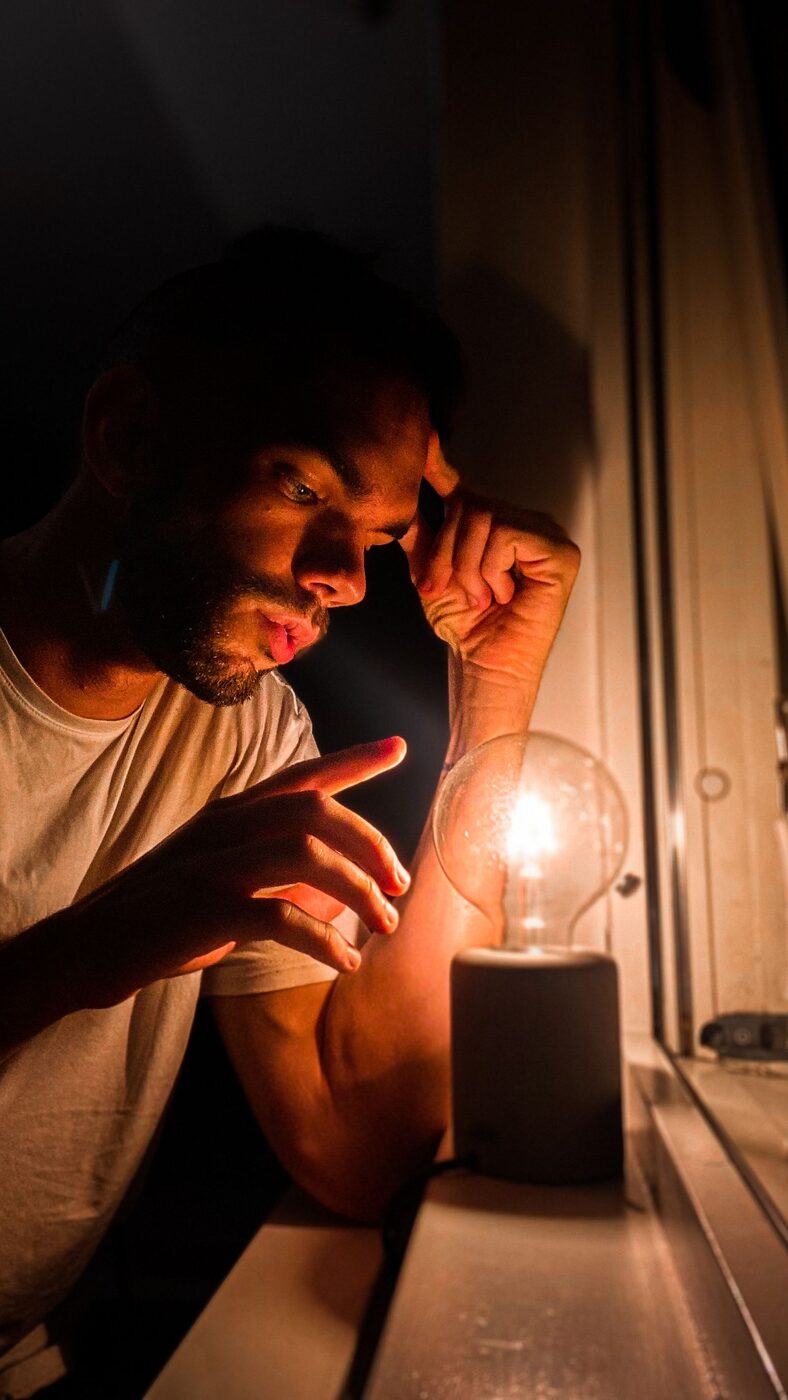 Man in a suit holding a glowing lightbulb